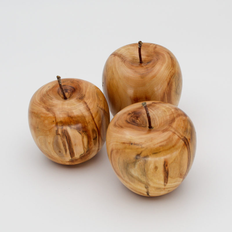Trois pommes décoratives en bois d'abricotier vue du dessus