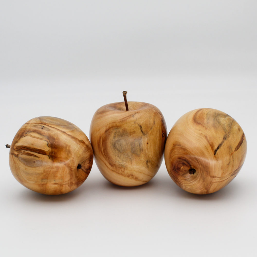 Trois pommes décoratives en bois d'abricotier vue de coté
