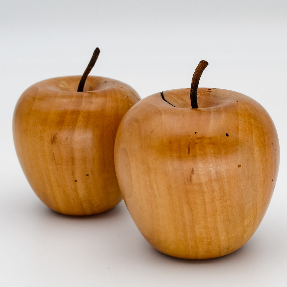 Deux pommes décoratives en bois de pommier vues de près