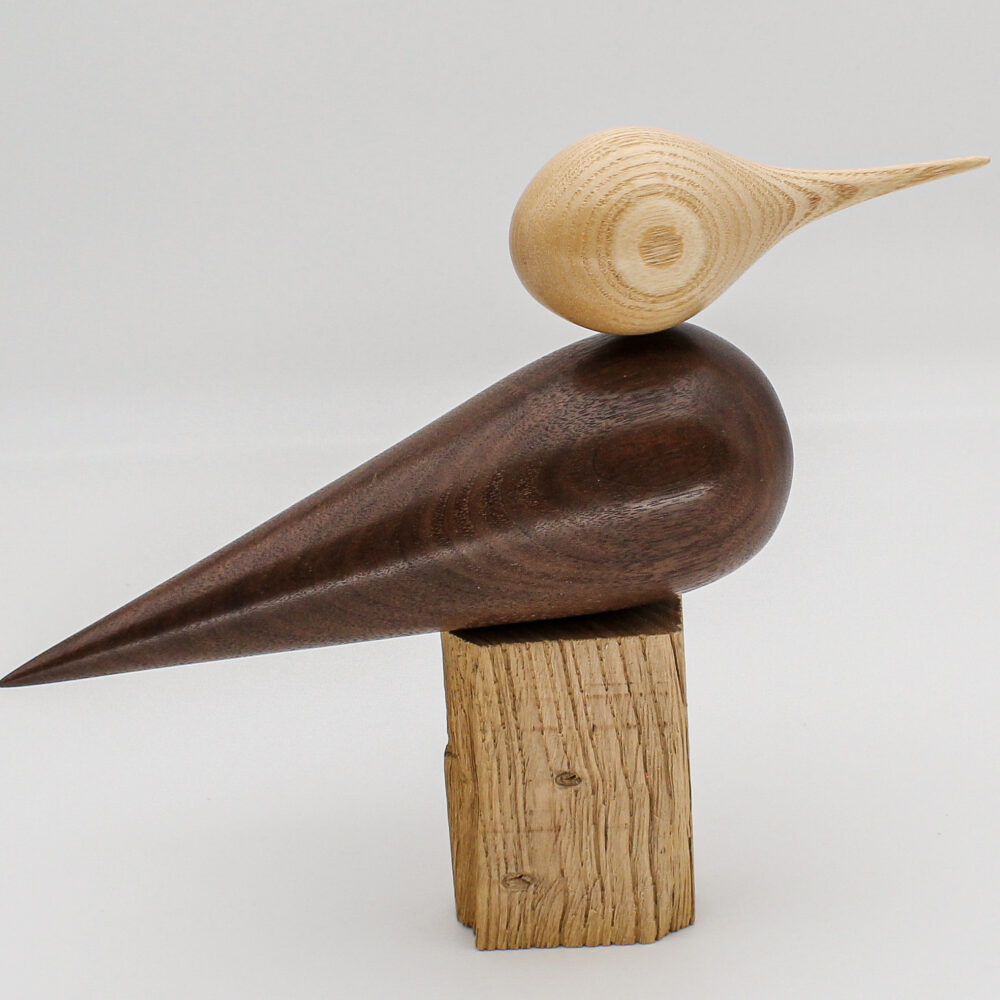 oiseau décoratif en bois de noyer et tête en bois de frêne posé sur un support vue de coté