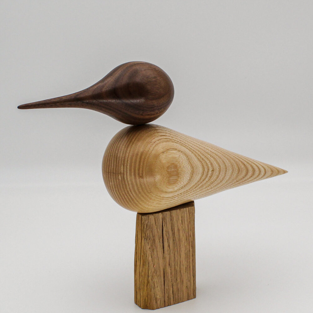 oiseau décoratif en bois de frêne et tête en bois de noyer posé sur un support vue de face